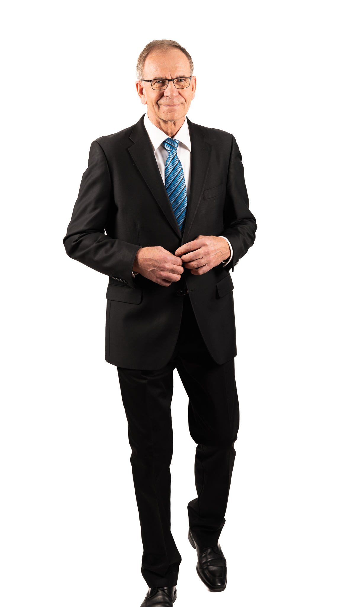 Tyylikkäästi pukeutunut, arvokas mies astelee kohti.